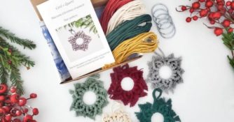 macrame ornaments of different colors with box, instructions, yarn, and rings